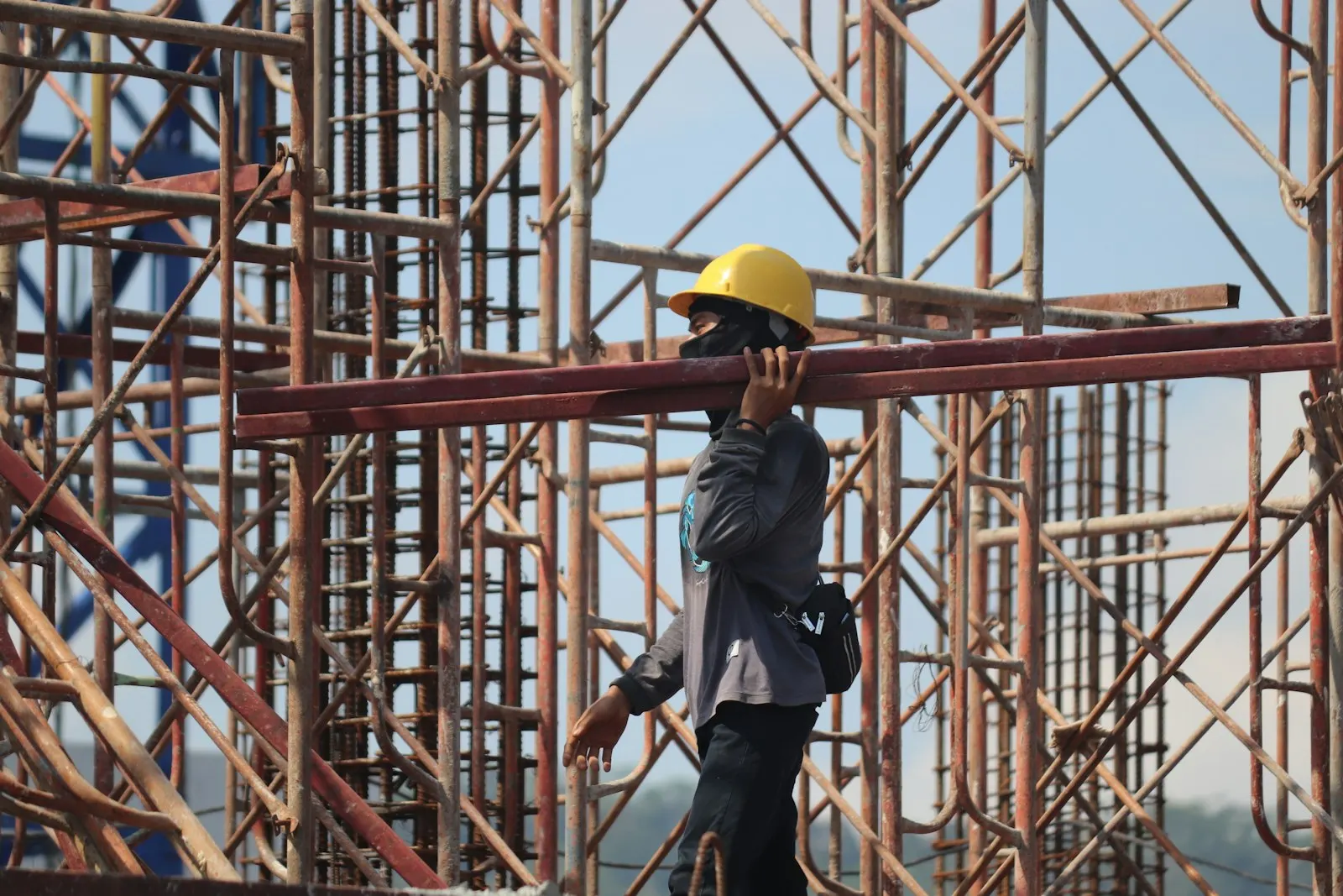 Massive site crew carrying steel on scaffolding